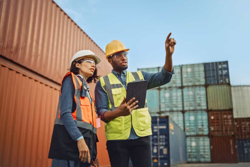 Container yard workers inspecting cargo containers at a shipping port.