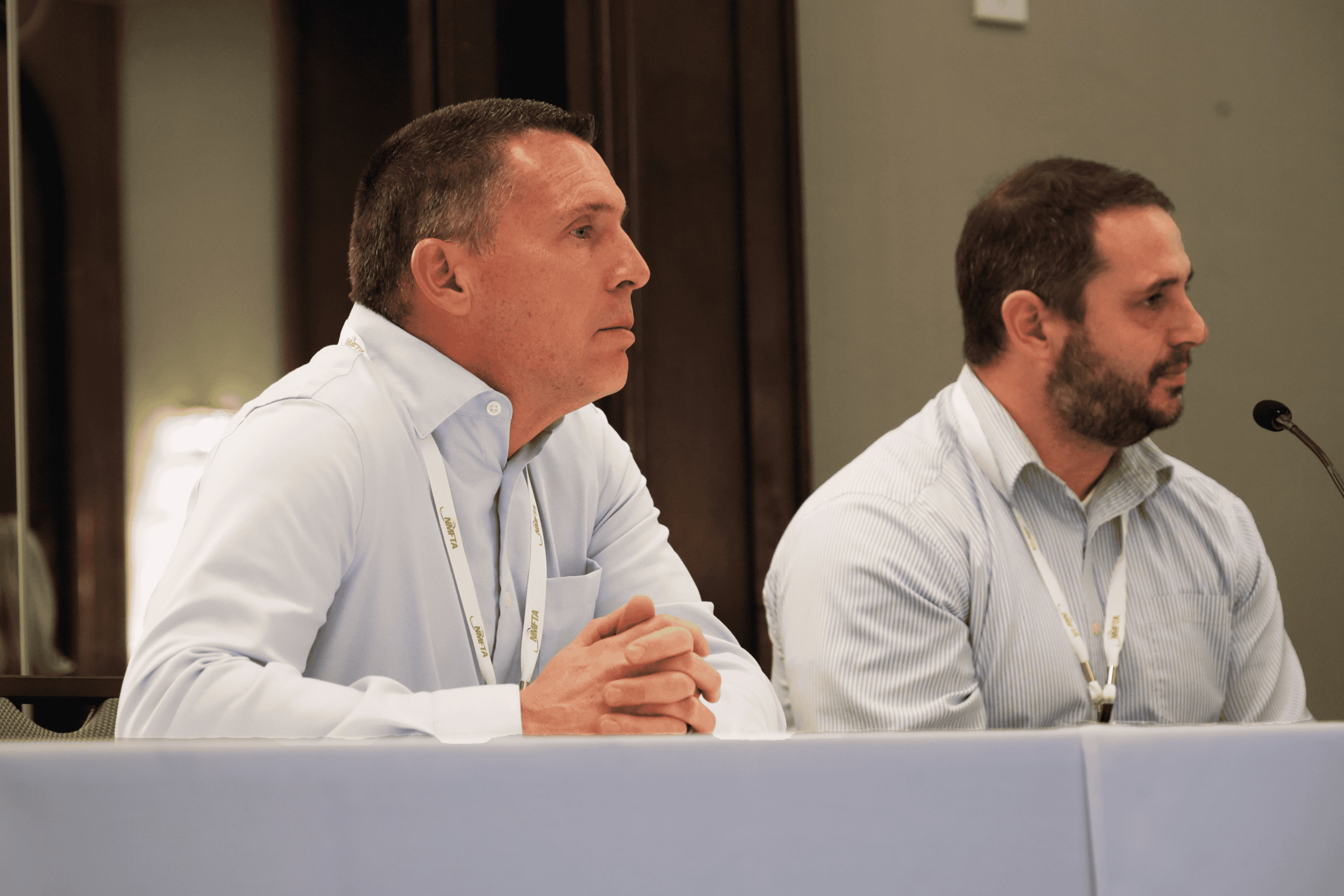 Chris Thacker seated at a panel table listening during a trucking industry conference discussion