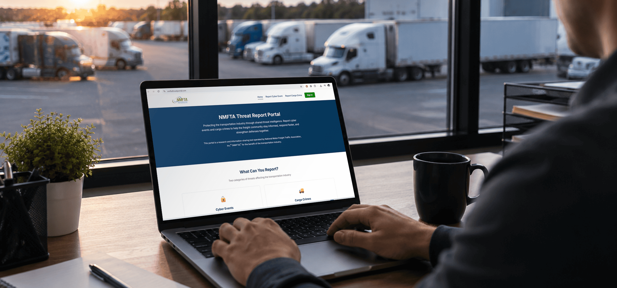 Transportation professional using the NMFTA Threat Report Portal on a laptop while overlooking a truck yard, highlighting cybersecurity, cargo crime reporting, and freight industry threat intelligence.